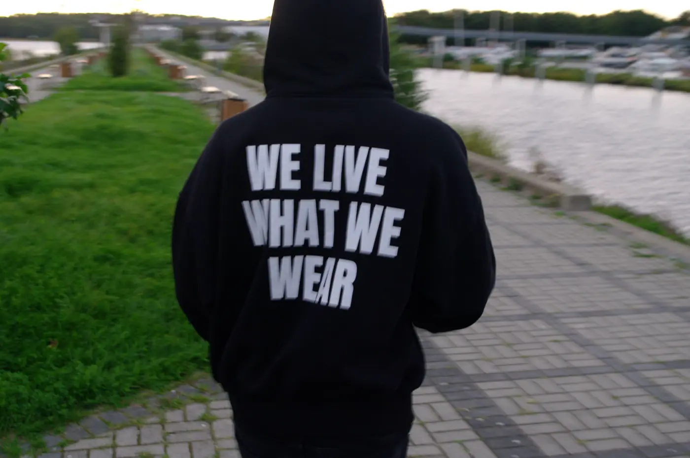 Plecy bluzy z dużym napisem WE LIVE WHAT WE WEAR
