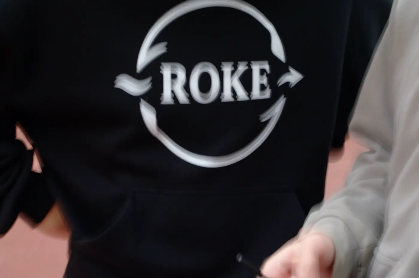 Zbliżenie na wyszyte logo ROKE na piersi bluzy